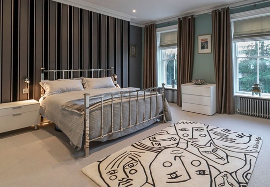 Modern bedroom with stylish decor and feature rug, listed by Spartan Property Estate Agents.