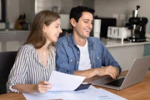Couple reviewing property options online with Spartan Property Estate Agents, smiling in a modern kitchen.